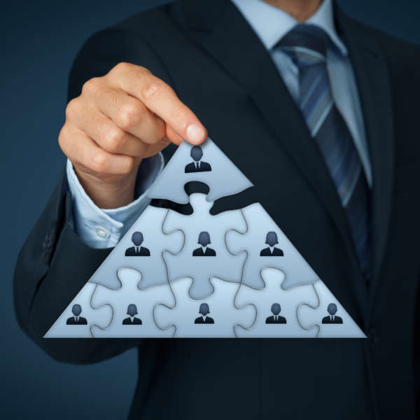 Leader and CEO CEO, leadership and corporate hierarchy concept - recruiter complete team represented by puzzle in pyramid scheme by one leader person (CEO).